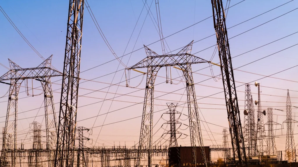 Energy grid towers in front a sunset.