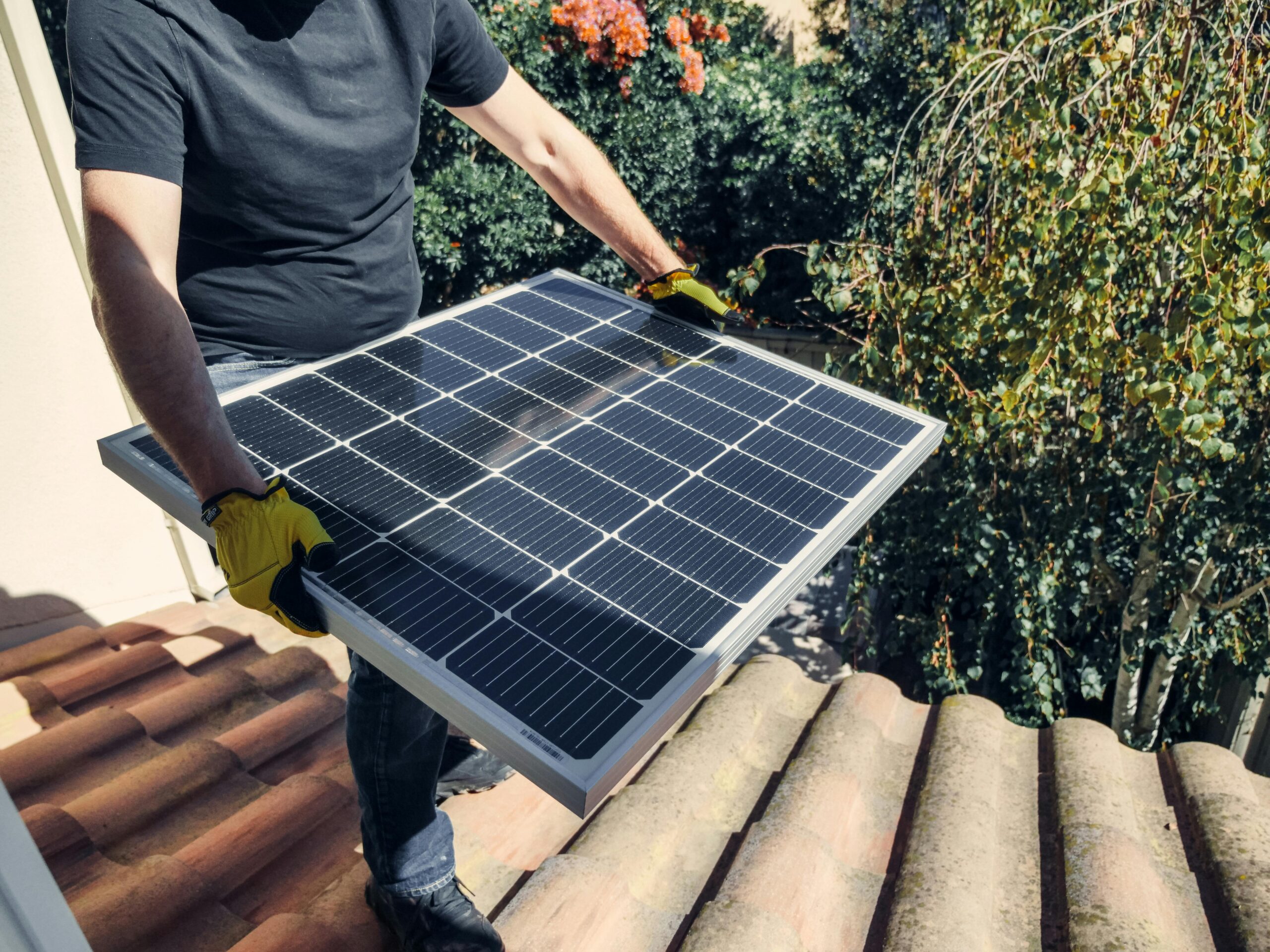 A person installing a solar panel on a roof promoting a clean energy solution.